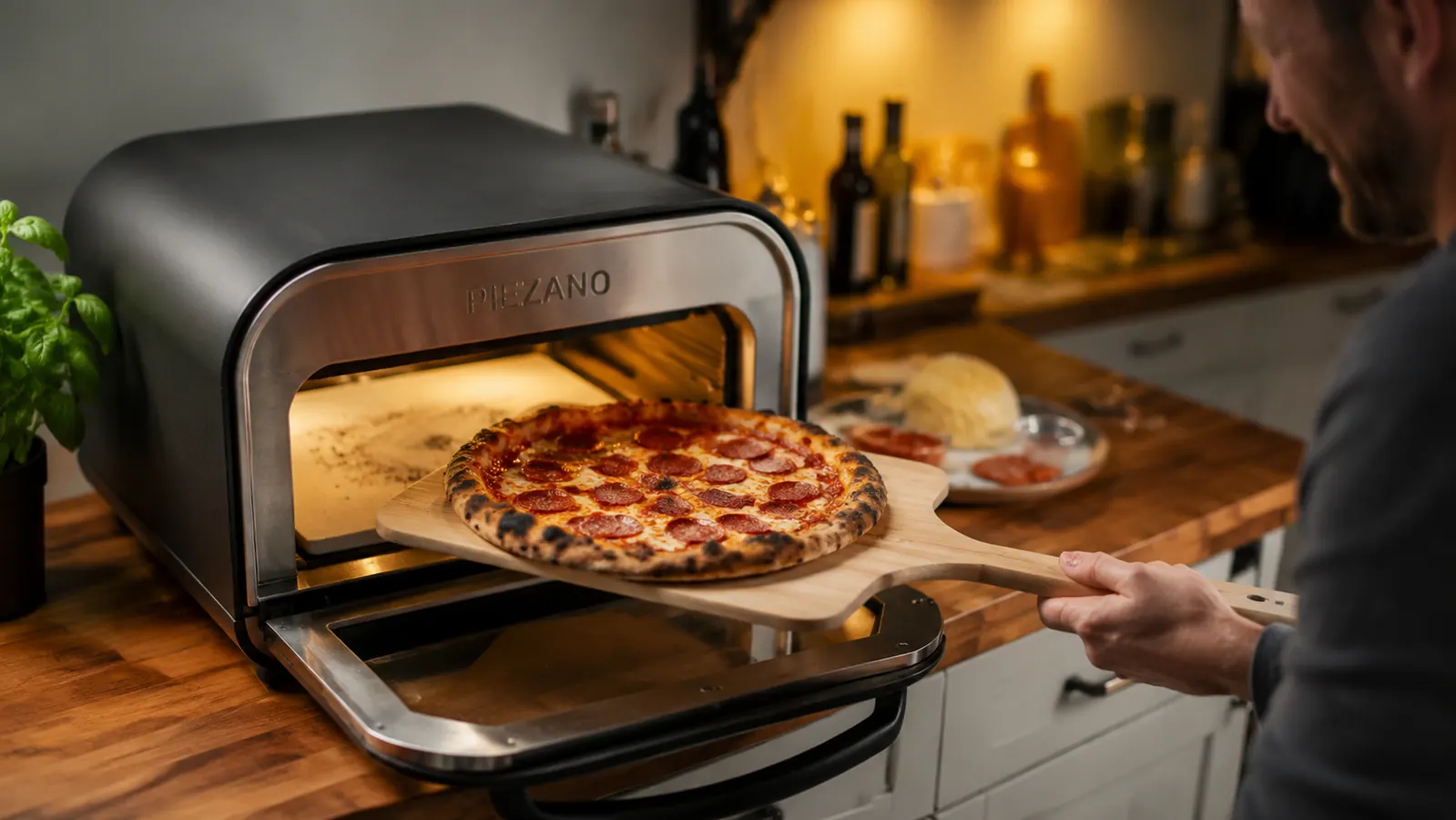 PIEZANO countertop electric pizza oven on a kitchen counter with a charred pepperoni pizza just pulled out