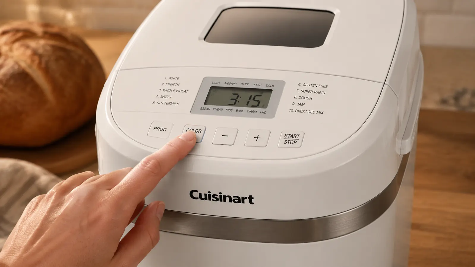 Hand pressing the crust setting button on the Cuisinart Bread Maker's control panel showing Light, Medium, and Dark options